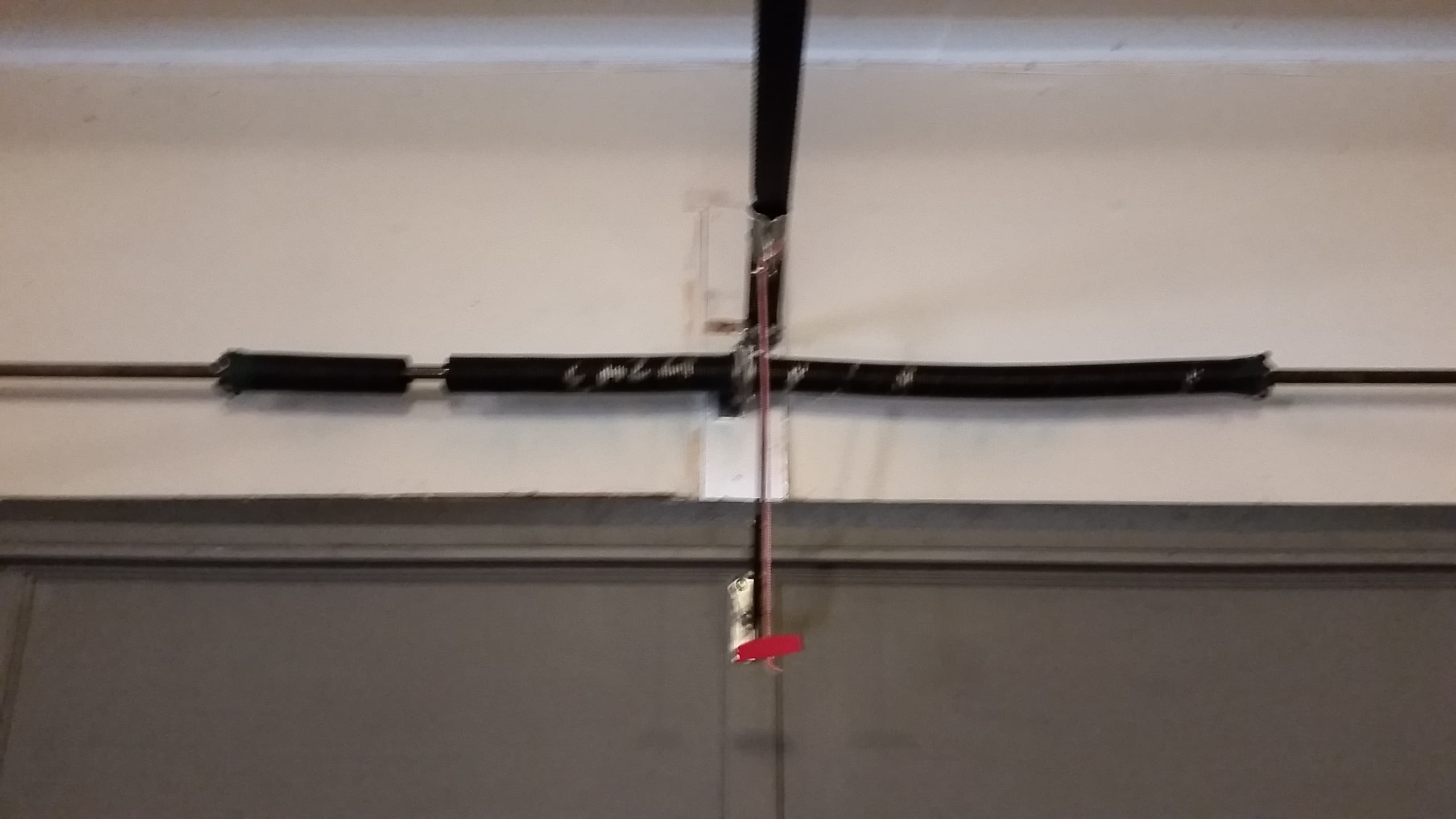 A torsion spring above a garage door, snapped into two pieces with a gap between the coils
